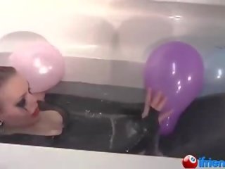 Lateks dressed adolescent with balloons in a bathtub