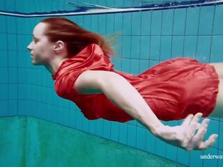 Rood lang jurk en groot tieten floating in de zwembad