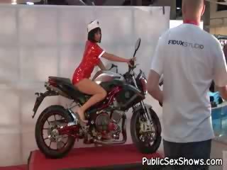 Delicioso pechugona morena vestido como enfermera posando en bike en desvistiéndose película